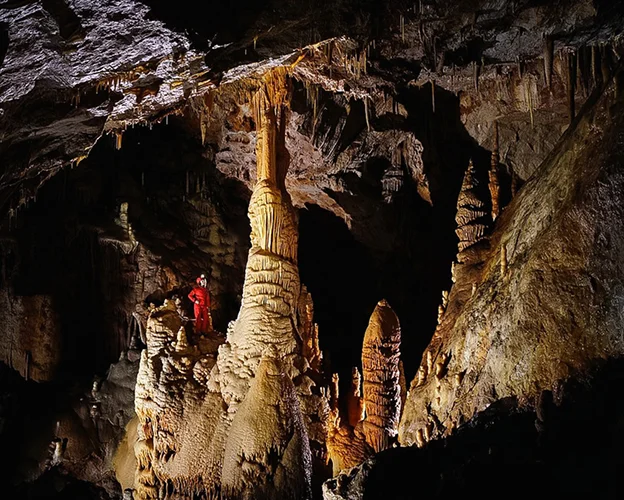 Un couple souriant dans une grotte, l'homme tient un micro à Meyrueis en Lozère 48