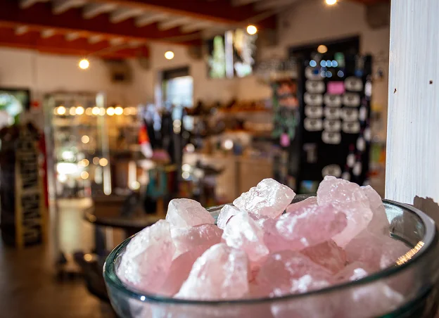 Cristaux de quartz rose dans un bol, intérieur de magasin flou en arrière-plan à Meyrueis en Lozère 48