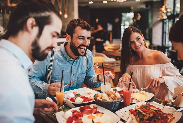 Amis souriants profitant d'un repas dans un restaurant moderne à Meyrueis en Lozère 48